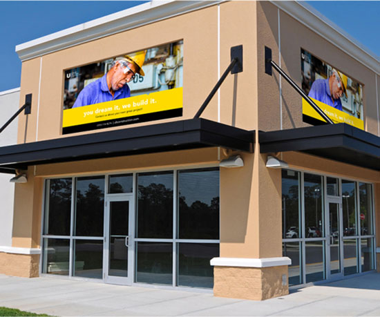 A large building featuring a prominent yellow sign displayed on its front facade.