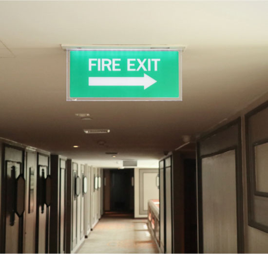 A fire exit sign is prominently displayed in a hallway, indicating the route to safety in case of an emergency.