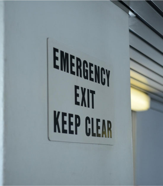 Emergency exit sign indicating to keep the area clear for safety and quick access in case of an emergency.