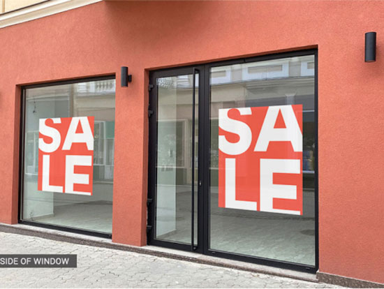 A store front featuring prominent sale signs displayed on the windows, inviting customers to explore discounts.