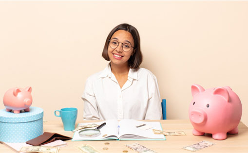 A woman at a desk, thoughtfully examining a piggy bank alongside stacks of money, symbolizing savings and financial planning.