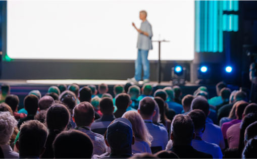 A man presenting at a conference, engaging the audience with visual aids and clear communication.