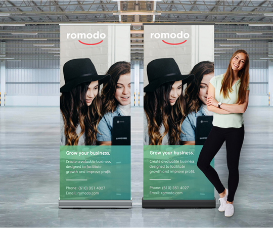 A woman stands beside a roll-up banner, showcasing a professional setting and engaging presentation.