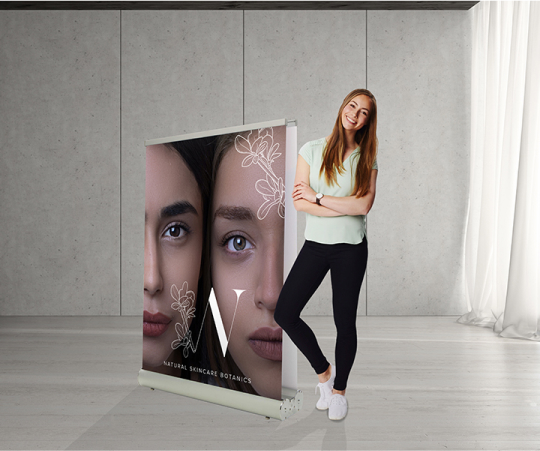 A woman stands beside a roll-up banner, showcasing a professional setting and engaging presentation.