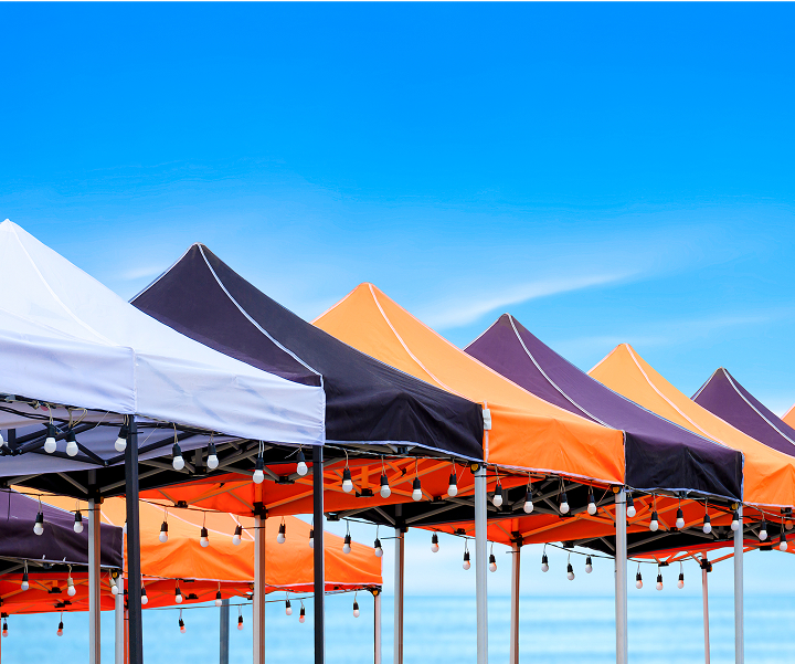 A row of tents featuring distinctive orange and black stripes, set against a clear background.