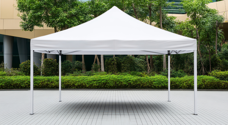 A white tent positioned on a paved surface, providing a sheltered area for gatherings or events.