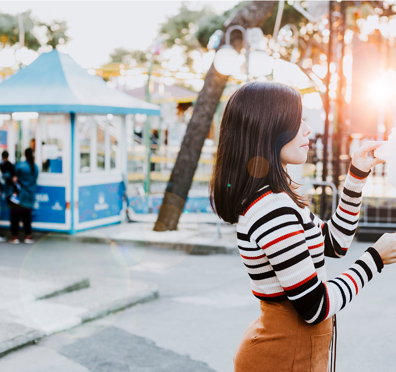 A woman smiling while taking a selfie with her smartphone, capturing a moment of joy and self-expression.