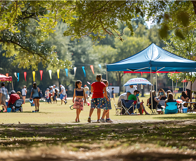 A diverse group of people gathered under a large tent, engaged in conversation and enjoying the outdoor event.