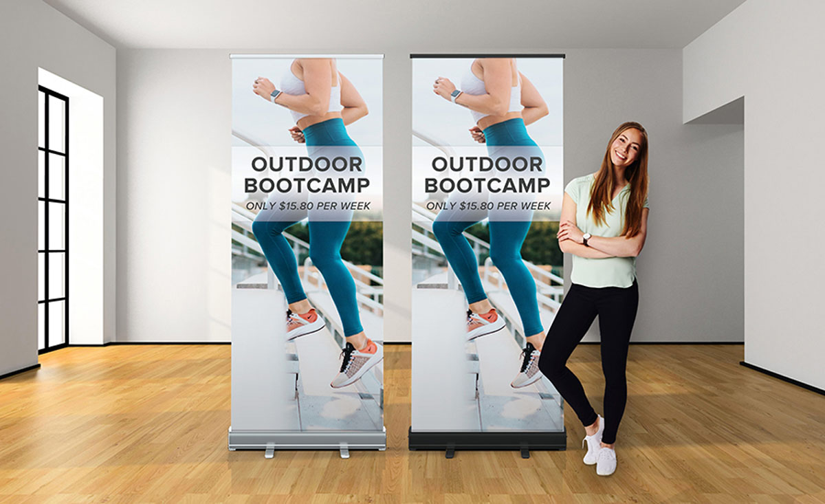 A woman stands beside a roll-up banner, showcasing a professional setting and engaging presentation.