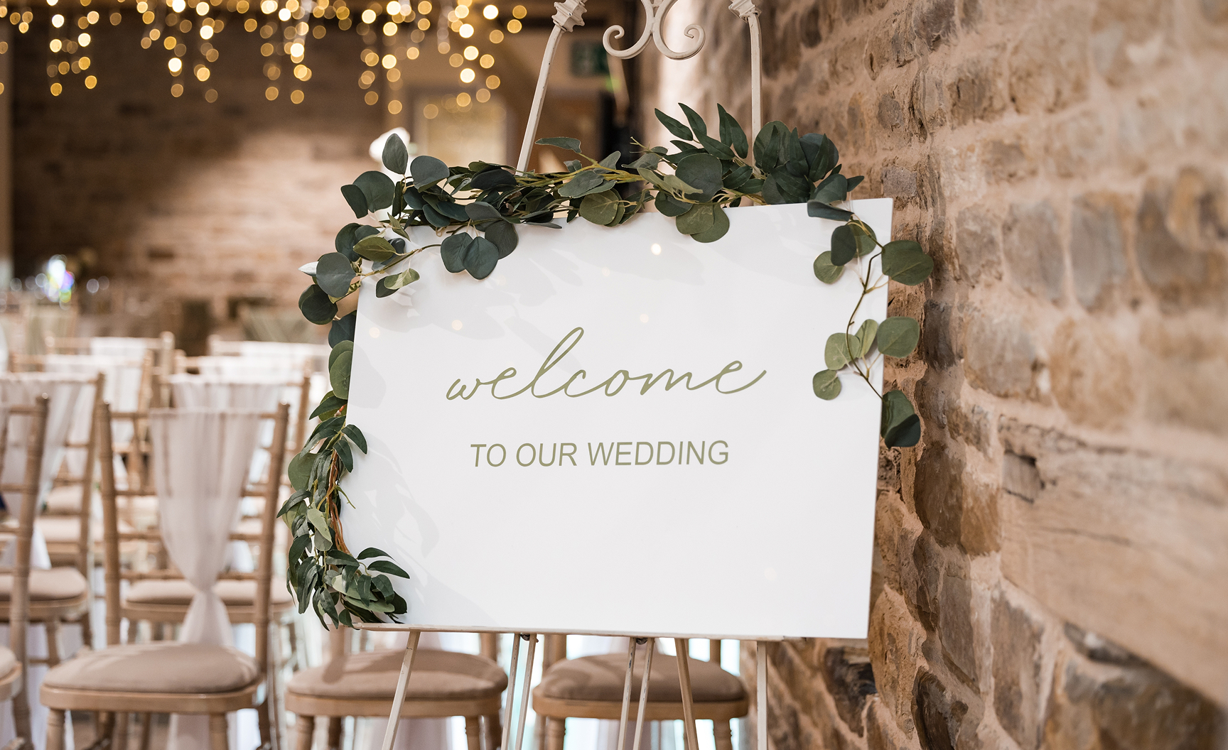 Wedding sign displayed at a rustic barn, elegantly guiding guests at a charming mill venue.