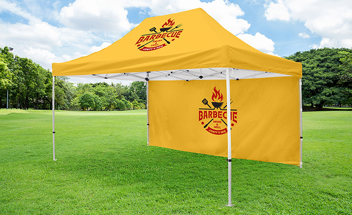 A yellow tent featuring a prominent logo displayed on its side.